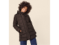 Besišypsanti moteris juoda pūsta striuke ir mėlynais džinsais