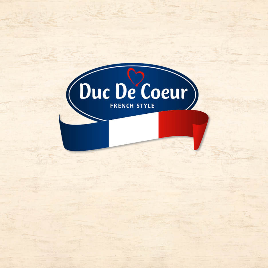 „Duc De Coeur“ logotipas su prancūziškos vėliavos juostele ant medinio fono.