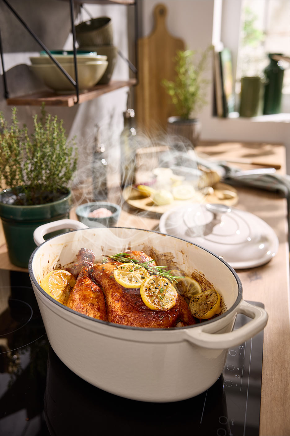 Garuoja kepta višta su citrinomis ir rozmarinais ketaus puode ant kaitlentės virtuvėje.