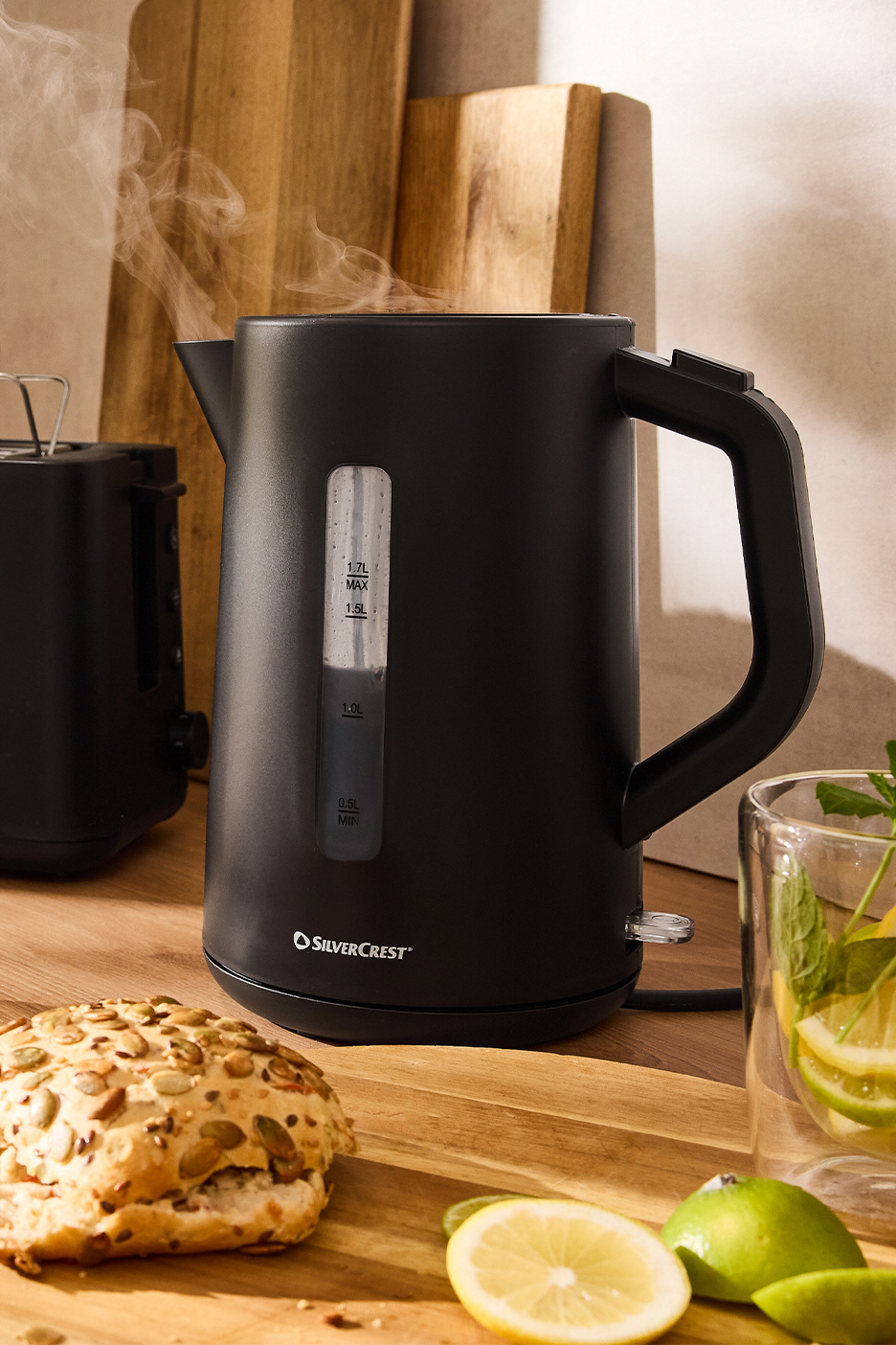 SilverCrest juodas virdulys su garuojančiu vandeniu, duona ir citrusiniais vaisiais