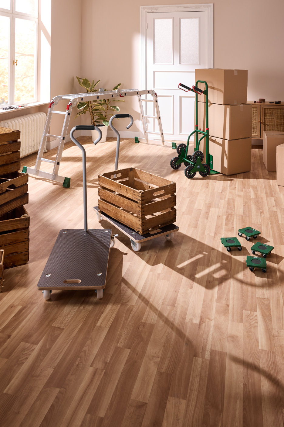 Įvairūs vežimėliai ir kopėčios, skirti daiktams perkelti ir namams atnaujinti.