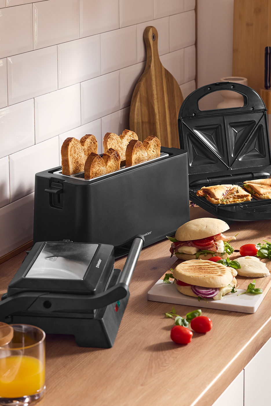 Virtuvės stalviršis su skrudintuvu, sumuštinių keptuve ir panini sumuštiniais.