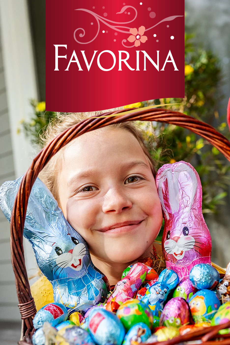 Šypsosi mergaitė su velykiniu krepšeliu, pilnu šokoladinių zuikučių ir kiaušinių.