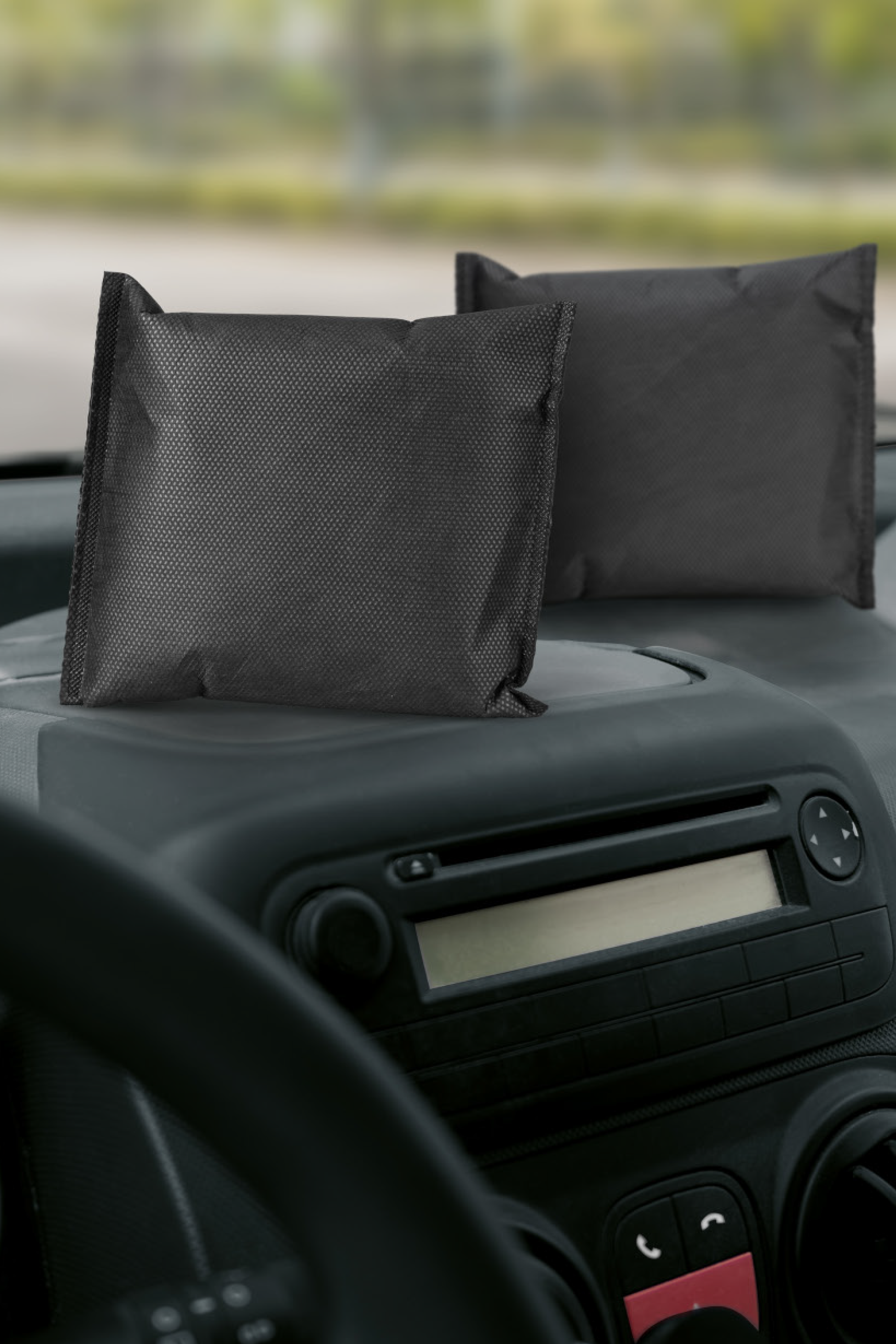 Du juodi oro gaivikliai automobiliui ant prietaisų skydelio.