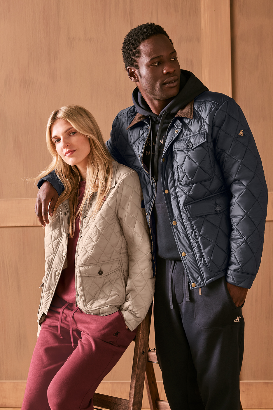 Vyras ir moteris, dėvintys dygsniuotas striukes ir sportines kelnes.