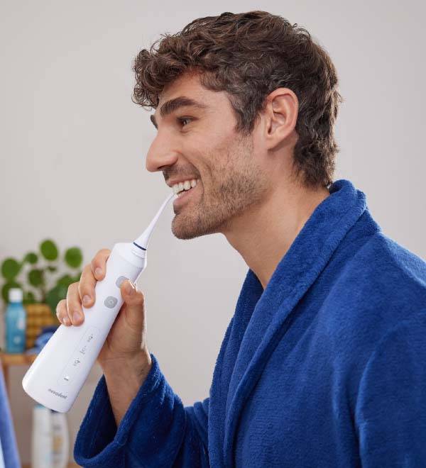 Vyras vonioje naudoja „Waterpik“ burnos higienos irigatorių.