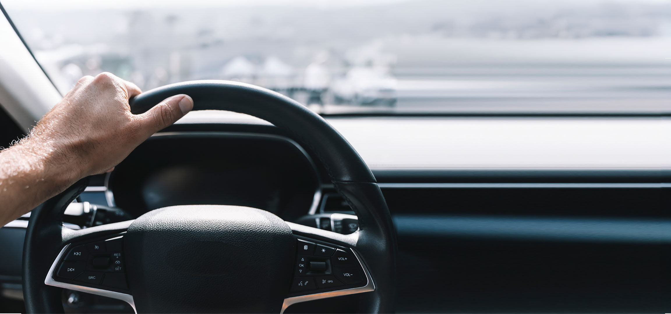 Vyro ranka laiko automobilio vairą.