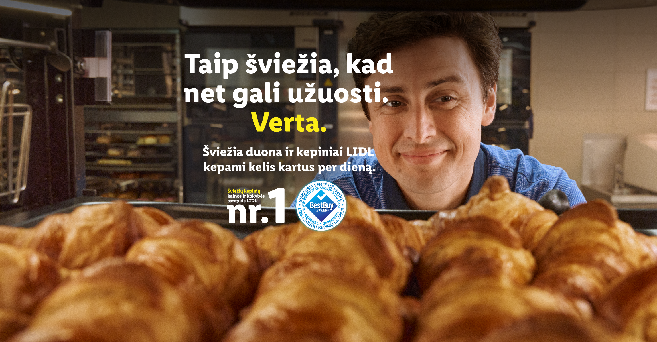 Vyras šypsosi už šviežių kruasanų padėklo, su tekstu apie šviežumą ir kepinių kokybę.