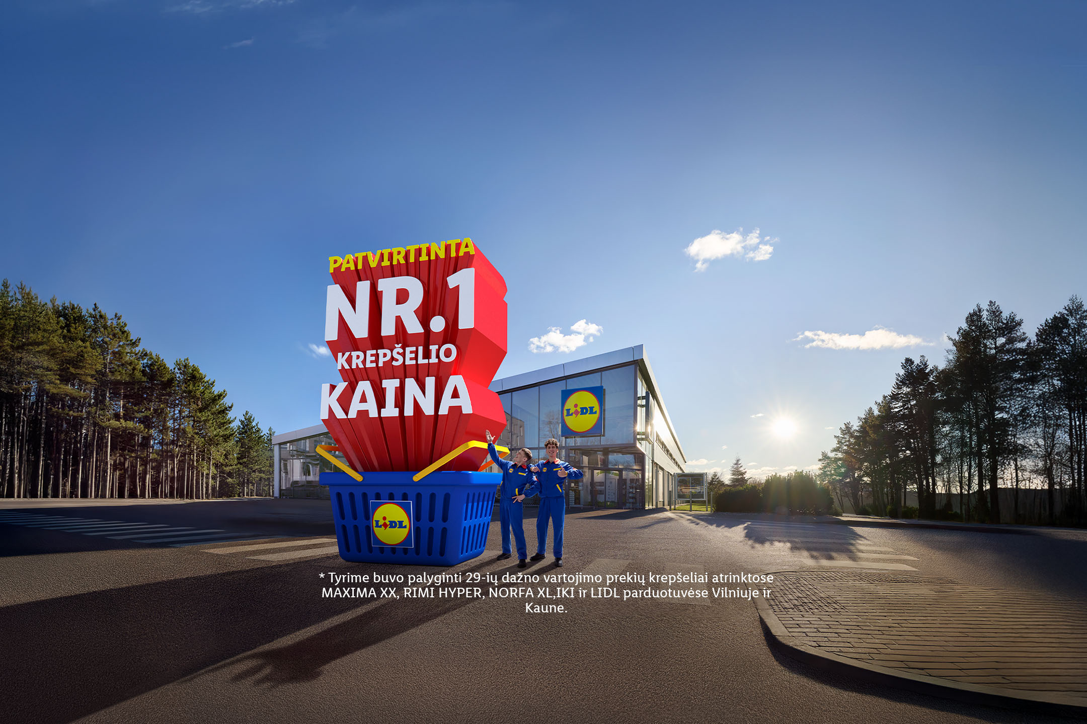 Lidl parduotuvės fone, du darbuotojai stovi prie didelio pirkinių krepšelio su užrašu „Patvirtinta Nr. 1 krepšelio kaina“.