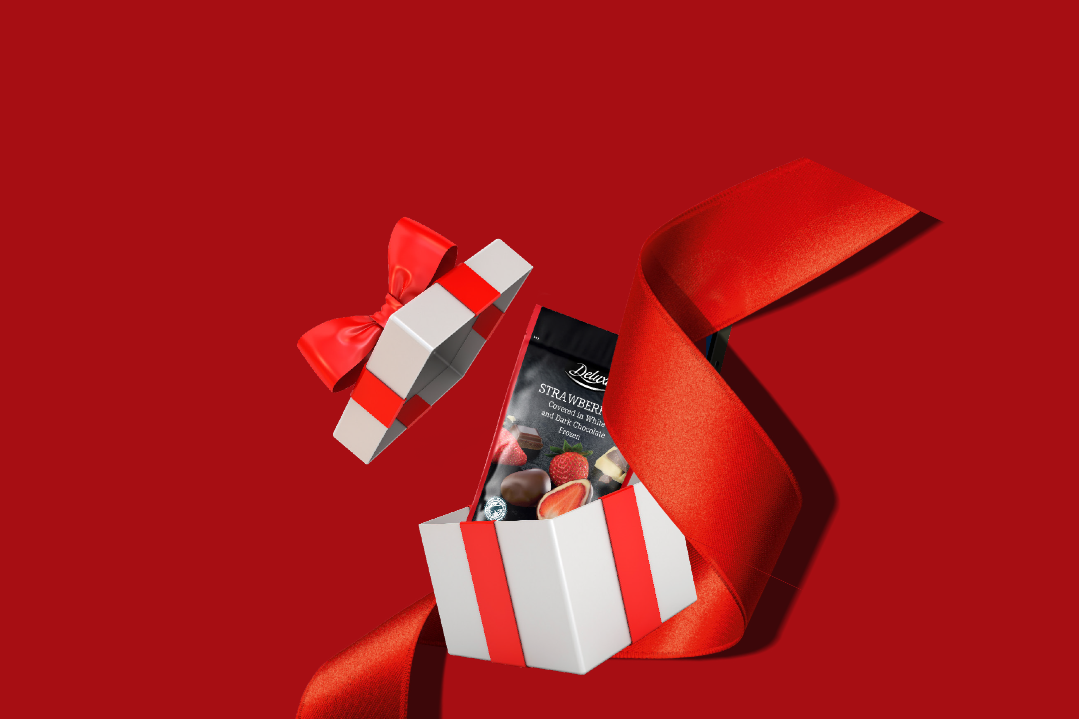 Dovanų dėžutė su „Deluxe“ šokoladu aplietomis braškėmis ir raudonu kaspinu.