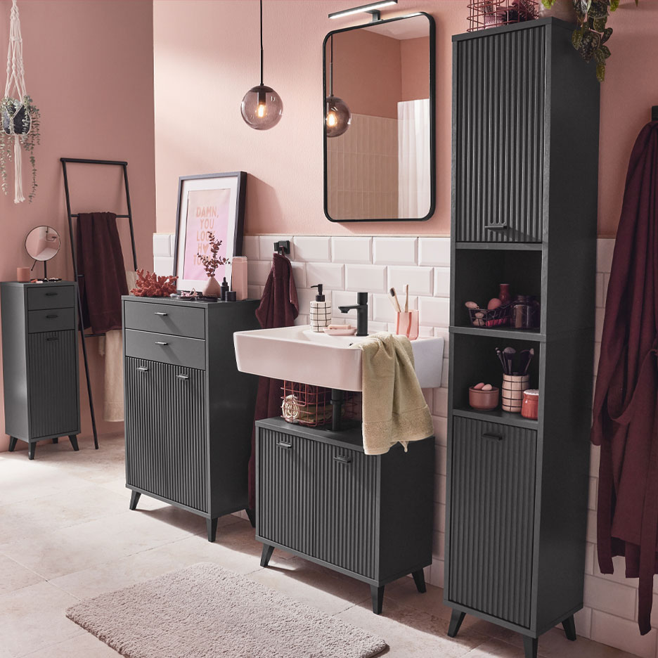 Modernus vonios kambarys su tamsiai pilkais baldais ir rožiniais akcentais.
