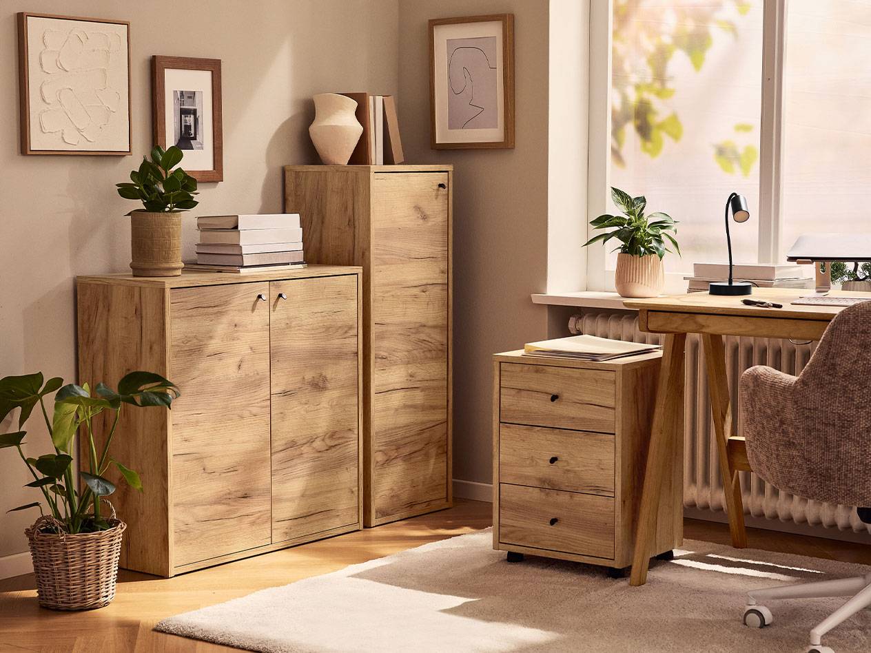 Namų biuras su šviesaus medžio spintelėmis, biuro kėde ir stalo lempa.