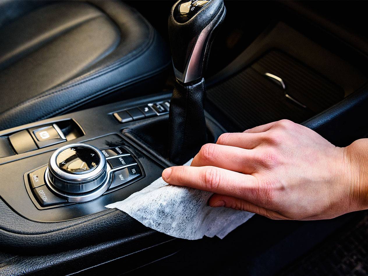 Ranka valo automobilio saloną drėgna servetėle.