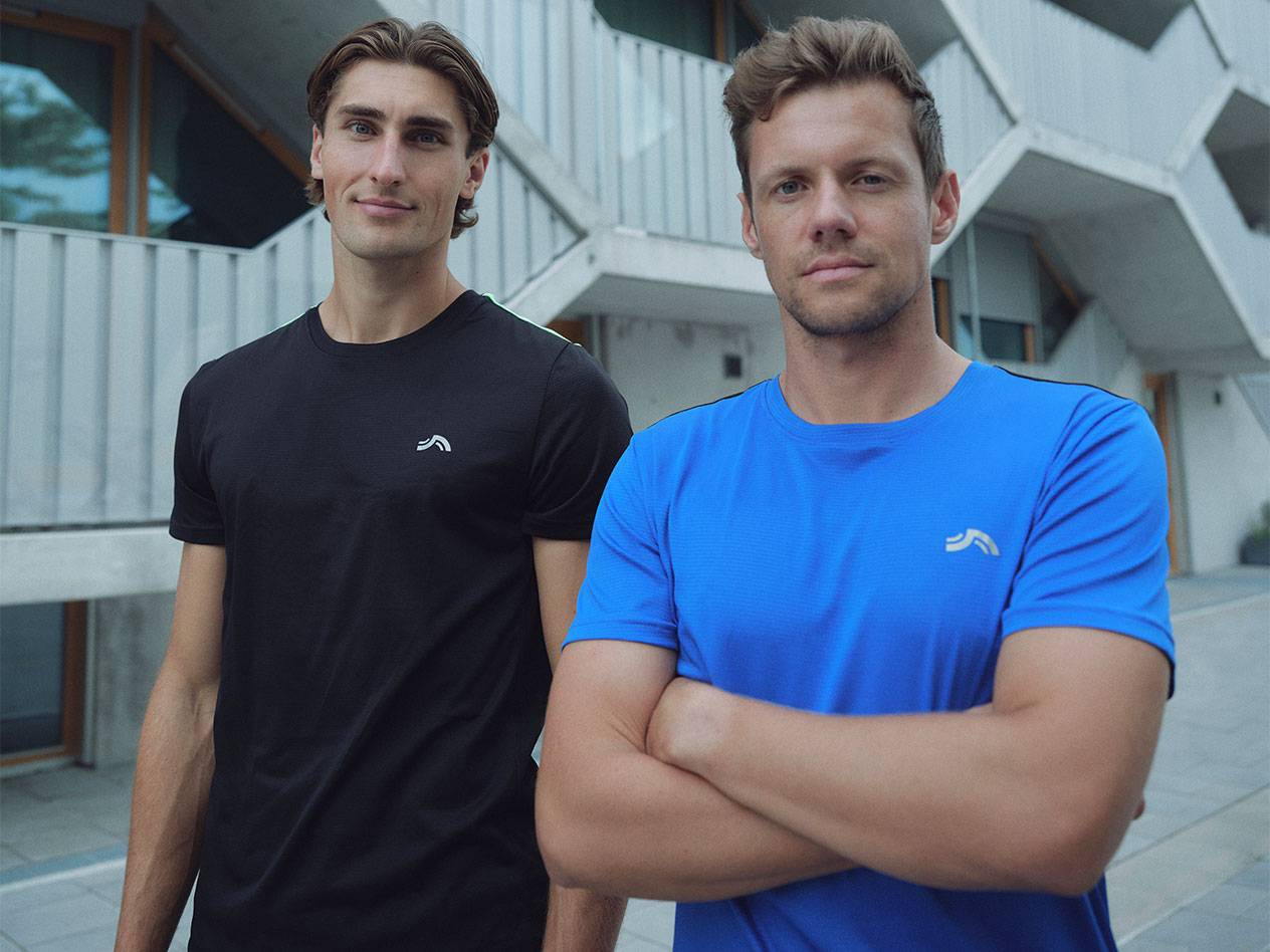 Du vyrai su juodais ir mėlynais sportiniais marškinėliais su logotipu.