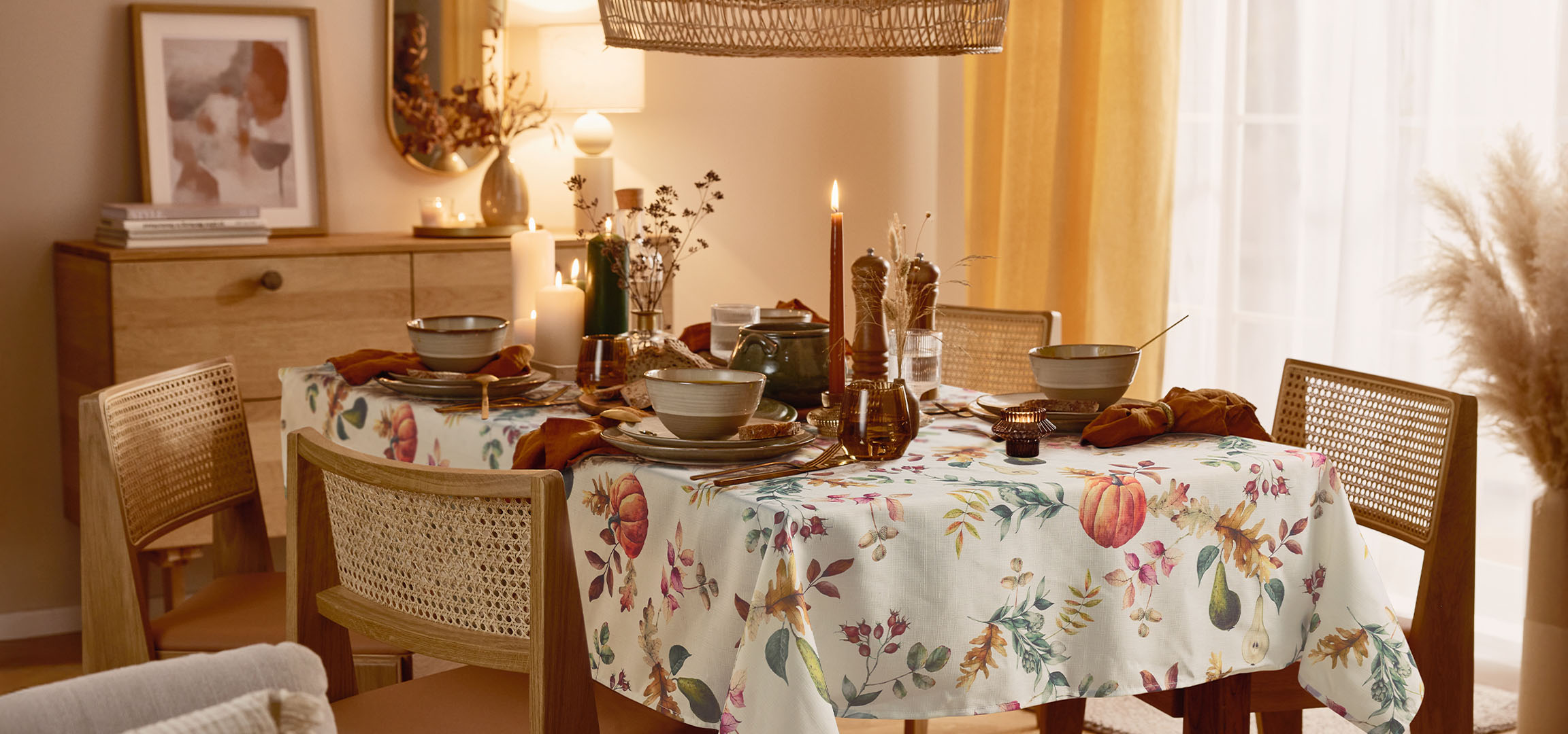 Valgomasis su stalu, paruoštu valgiui, su gėlėta staltiese ir šiltu apšvietimu.