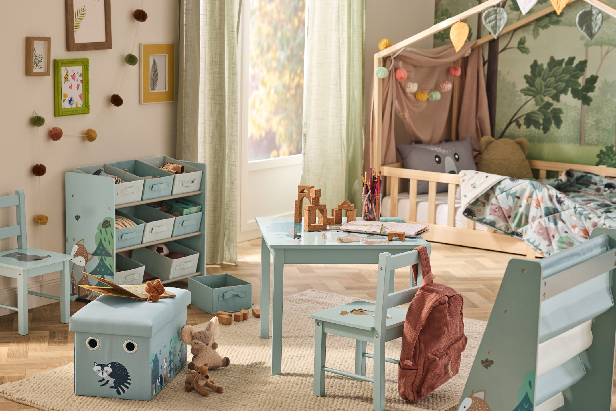 Vaikų kambarys su medine lova, žaislų lentyna, stalu ir kėdėmis miško tema.