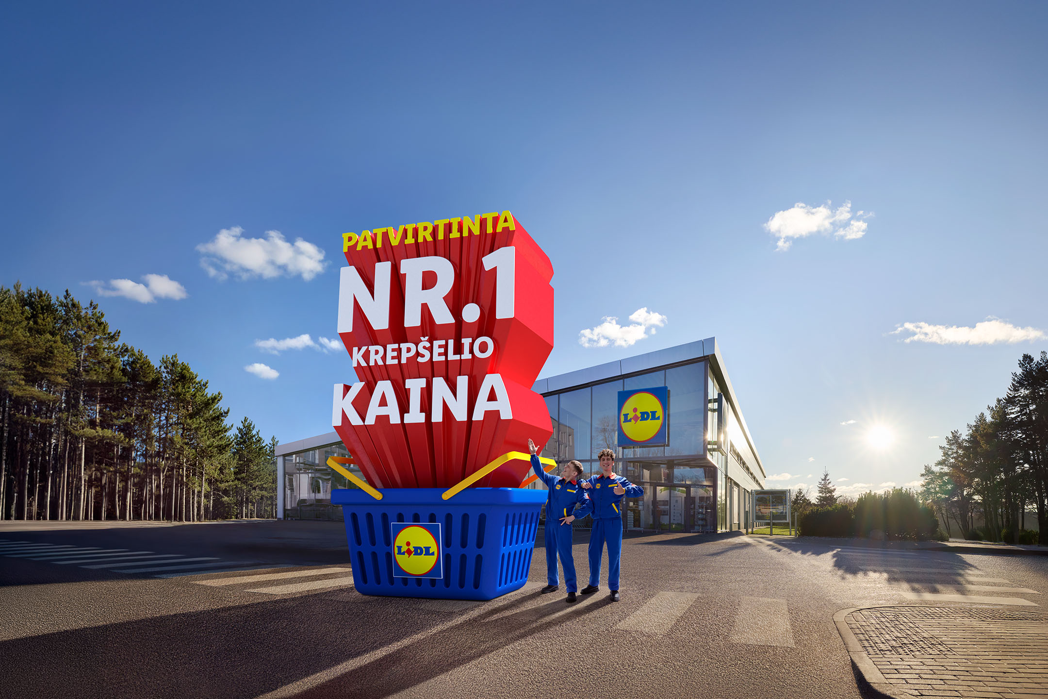 Lidl parduotuvė su milžinišku pirkinių krepšeliu, skelbiančiu „Patvirtinta Nr. 1 krepšelio kaina“, ir dviem darbuotojais.