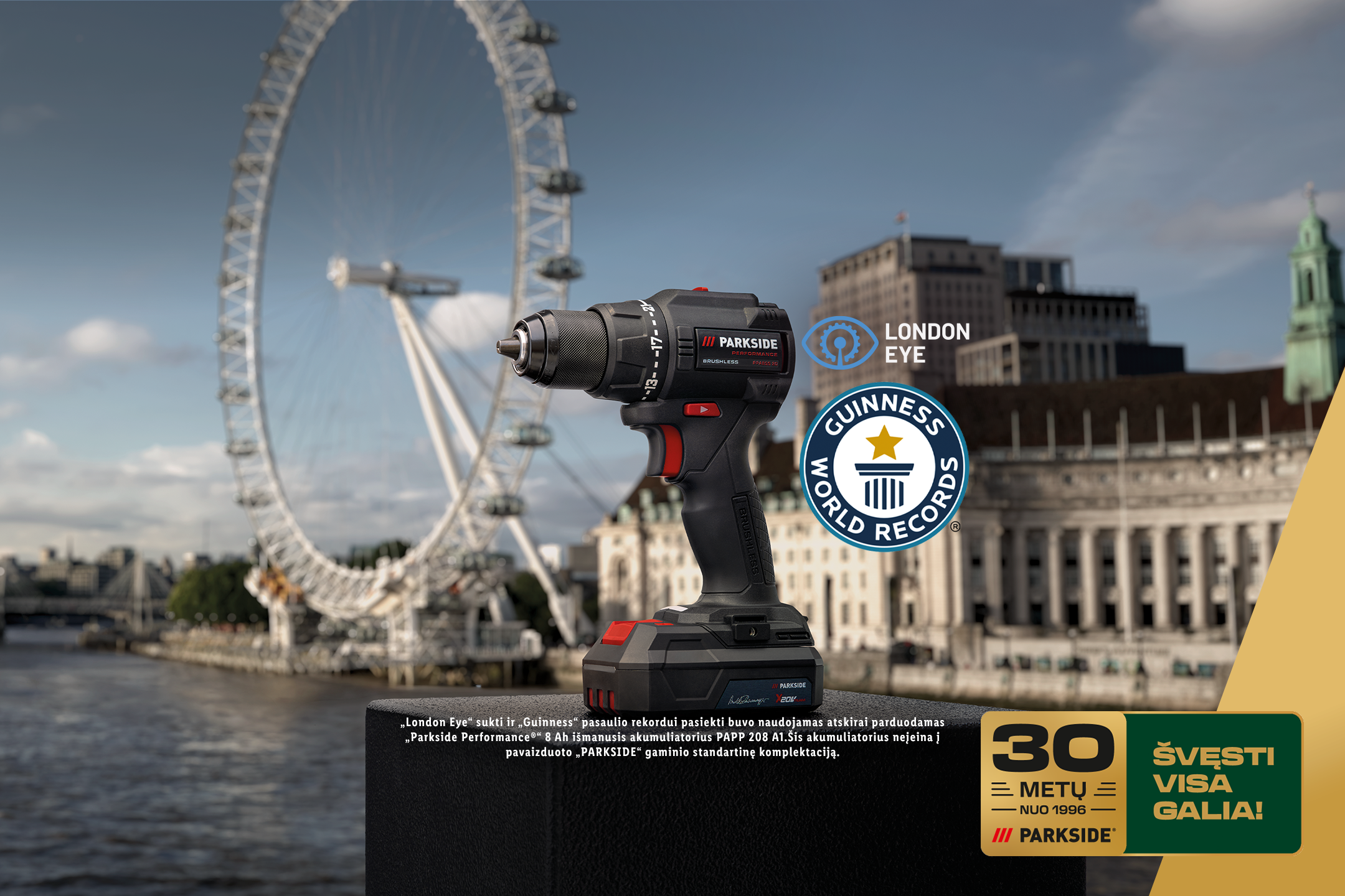 Akumuliatorinis gręžtuvas-suktuvas su baterija, Londono panoramos fone, su „Guinness World Records“ ir „London Eye“ logotipais, bei užrašu „30 metų nuo 1996. Švęsti visa galia!“